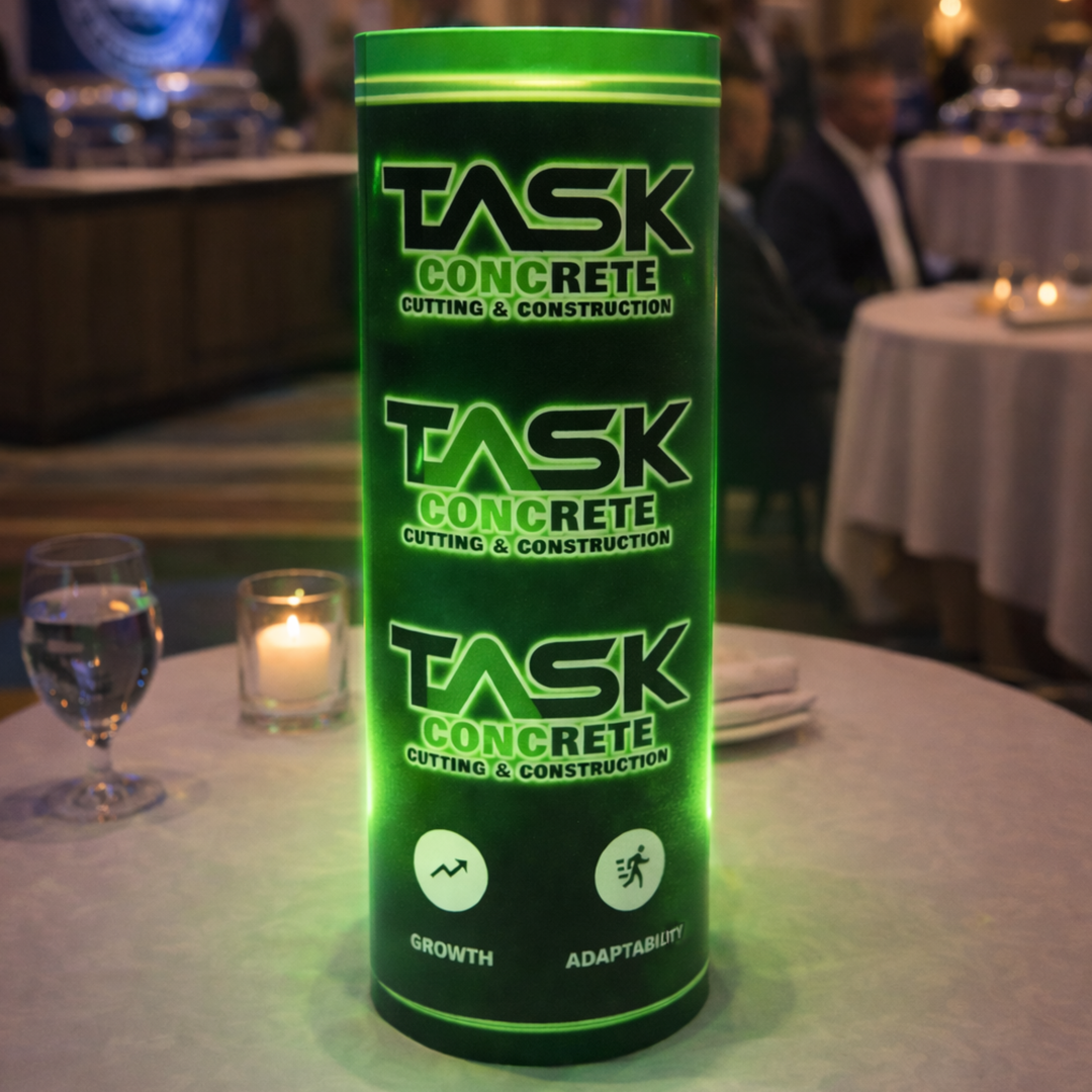 Green cylindrical container with 'Task Concrete' branding on a table with a blurred background